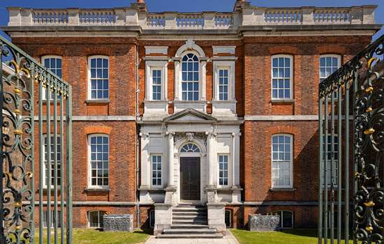 The facade of Ranger's House viewed through open iron gates.