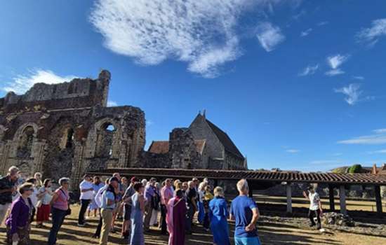 A group of people on a tour of St Augustine's Abbey on a sunny day.