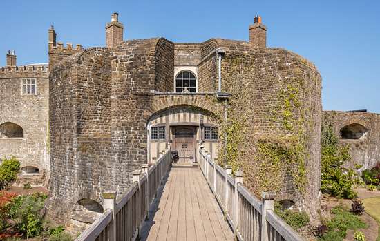 The entrance to Walmer Castle with view of a wooden bridge leading to the stone circular castle building.